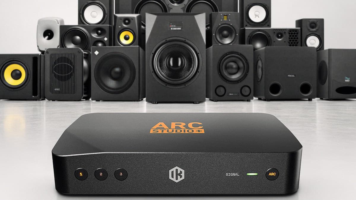 IK Multimedia ARC Studio+ room correction processor in front of studio monitors and subwoofers