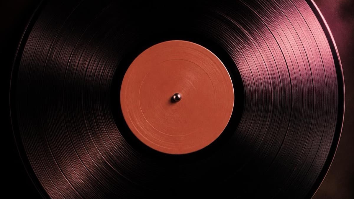 Close-up of a black 12-inch vinyl record spinning, illustrating Suno's new custom vinyl pressing service